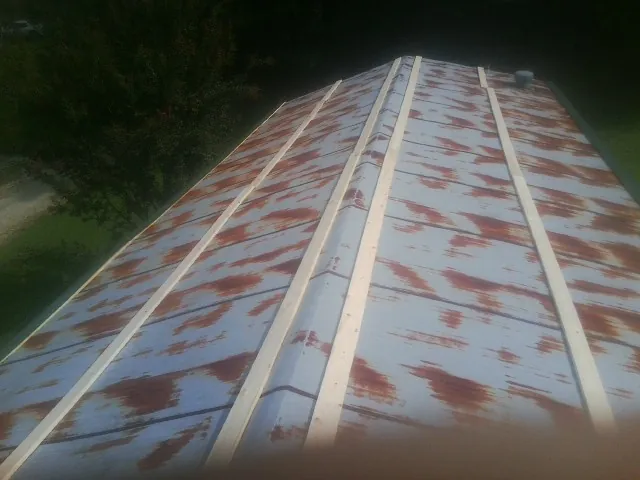 Rusted metal roof panels with new wood purlins before replacement — Storm Damage Roof Repair in Gibson by Roofing Brothers