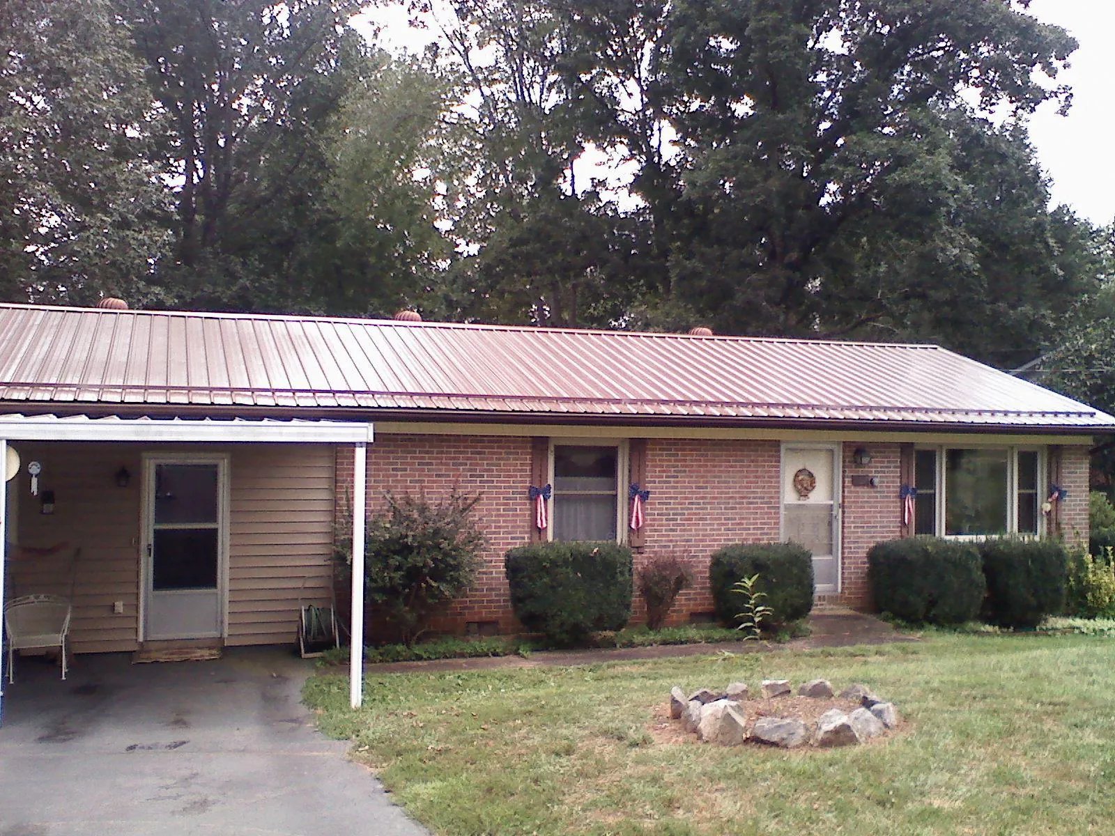Bronze metal roof and carport on a brick ranch home — Roof Repair work by our crew in Gibson